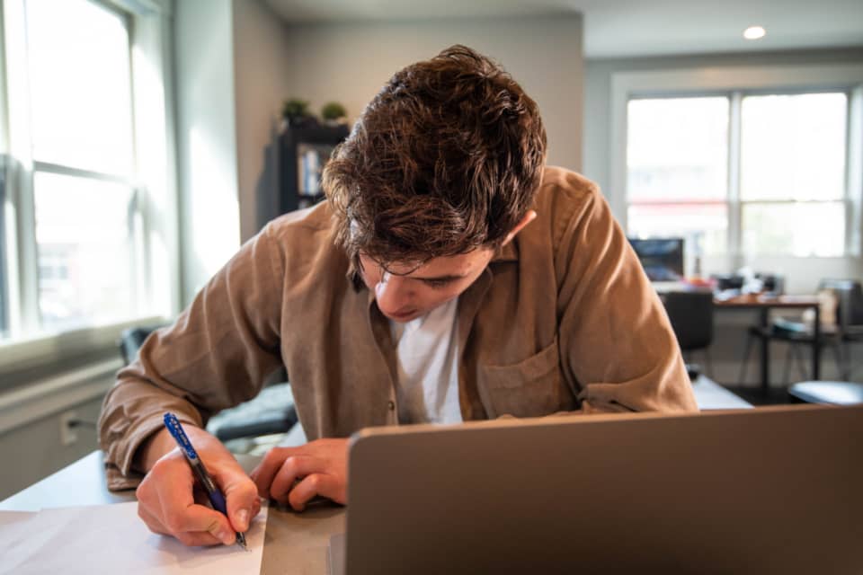 man writing plans to launch an online business on paper